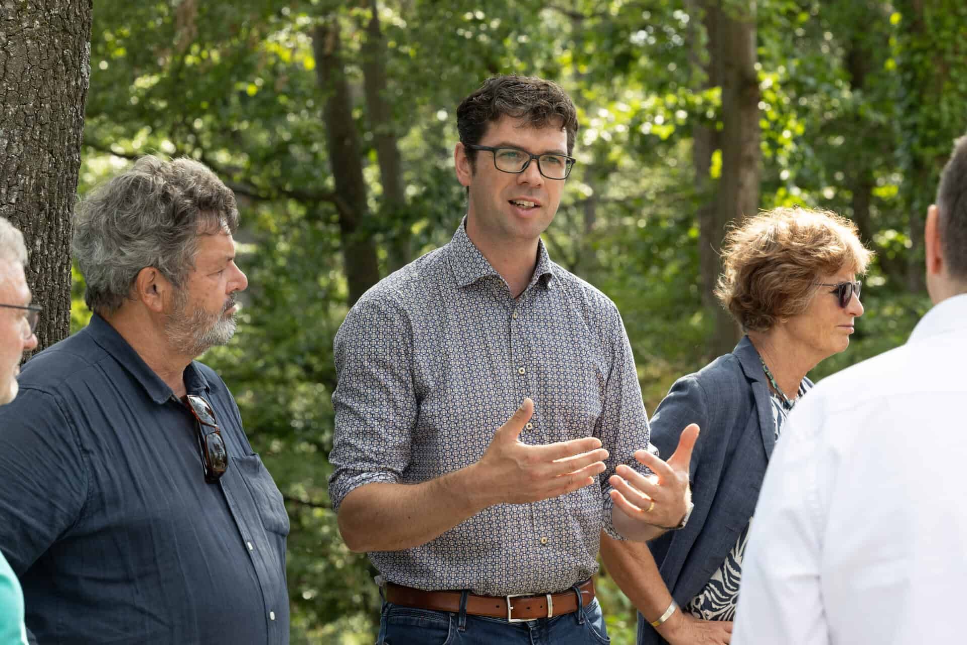 Ralf Nentwich, Mitglied des Landtags Baden-Württemberg, im Gespräch während eines Vor-Ort-Termins im Wald mit mehreren Teilnehmenden
